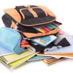 Flat lay of sustainable school supplies, including reusable containers, refillable pens, and eco-friendly notebooks.